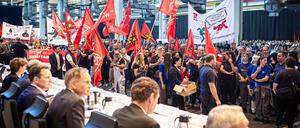 Mitarbeiter protestieren vor Beginn einer Betriebsversammlung in einer Halle im VW-Werk. 