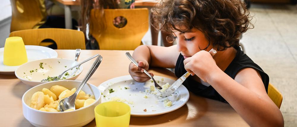 Kinder beim Essen in einer Schulmensa.