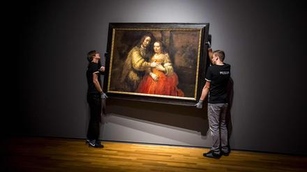 Ein echter Rembrandt: Zwei Männer hängen das Gemälde „Die jüdische Braut“ im Rijksmuseum in Amsterdam (Archivbild von 2019).