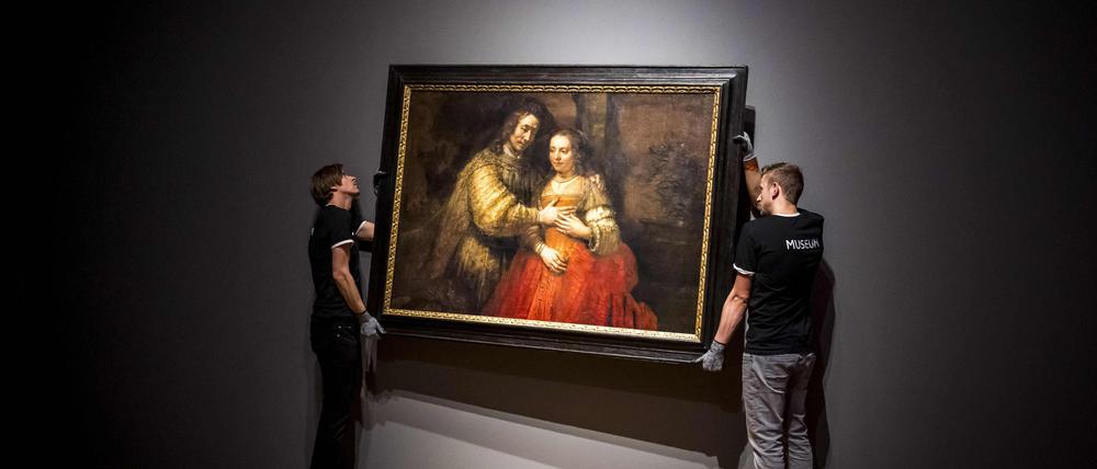 Ein echter Rembrandt: Zwei Männer hängen das Gemälde „Die jüdische Braut“ im Rijksmuseum in Amsterdam (Archivbild von 2019).