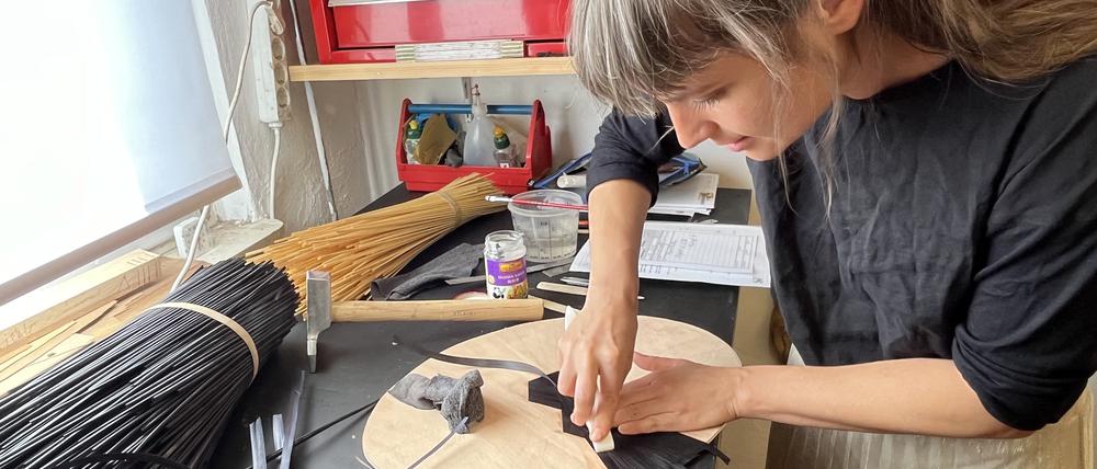 Tabea Vietzke, einige der wenigen Menschen in Berlin, die das Kunsthandwerk der Strohmarketerie beherrscht, bei der Arbeit.