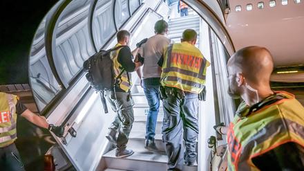 Polizeibeamte begleiten einen Afghanen auf dem Flughafen Leipzig-Halle in ein Charterflugzeug (Symbolbild).