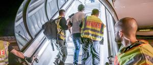 Polizeibeamte begleiten einen Afghanen auf dem Flughafen Leipzig-Halle in ein Charterflugzeug (Symbolbild).