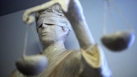 Die Statue Justitia ist in einem Gericht zu sehen.