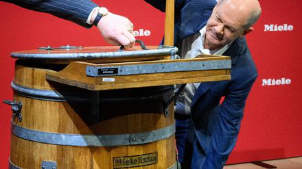 Bei Miele durfte Kanzler Olaf Scholz einen alten Waschzuber ausprobieren, eine Innovation von 1902. 