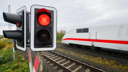Eine rote Ampel leuchtet an einem Bahnübergang.