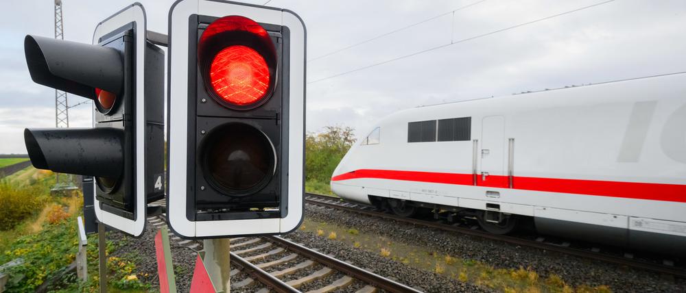 Eine rote Ampel leuchtet an einem Bahnübergang.