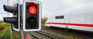 Eine rote Ampel leuchtet an einem Bahnübergang.