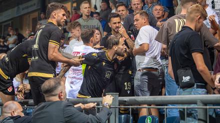 Niko Bretschneider (Mitte) wird auf der Tribüne des Karl-Liebknecht-Stadions von Mitspielern zurückgehalten. 