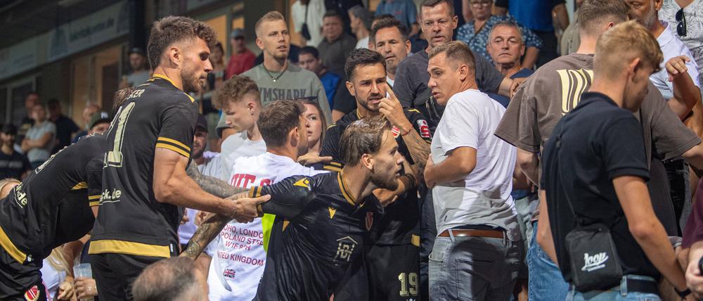Niko Bretschneider (Mitte) wird auf der Tribüne des Karl-Liebknecht-Stadions von Mitspielern zurückgehalten. 
