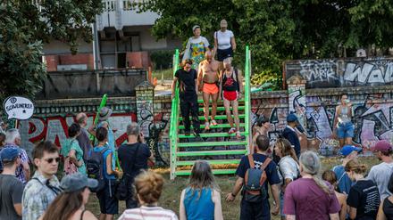 Teilnehmer einer Protestaktion in der in der Aktionswoche «Defence Görli» überqueren symbolisch eine provisorische Holztreppe über eine Mauer am Görlitzer Park als Protest gegen die geplante Umzäunung des Görlitzer Park. 