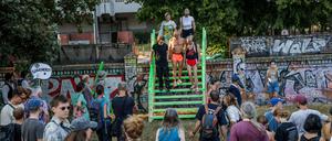 Teilnehmer einer Protestaktion in der in der Aktionswoche «Defence Görli» überqueren symbolisch eine provisorische Holztreppe über eine Mauer am Görlitzer Park als Protest gegen die geplante Umzäunung des Görlitzer Park. 