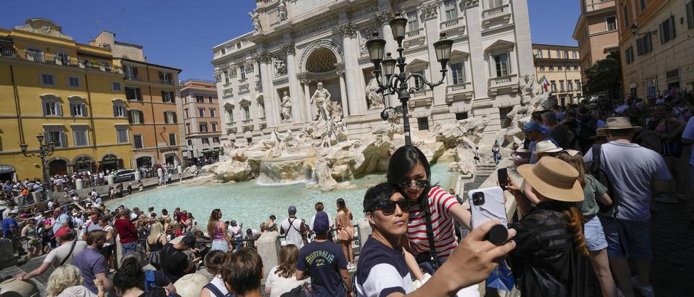 Touristen machen ein Selfie vor dem Trevi-Brunnen in Rom.