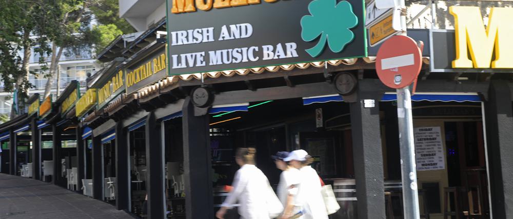 Menschen gehen an einer irischen Cocktail-Bar  in Magaluf vorbei. 