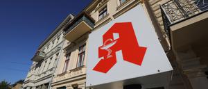 Eine Apothekenleuchte steht vor einer Altbaufassade.