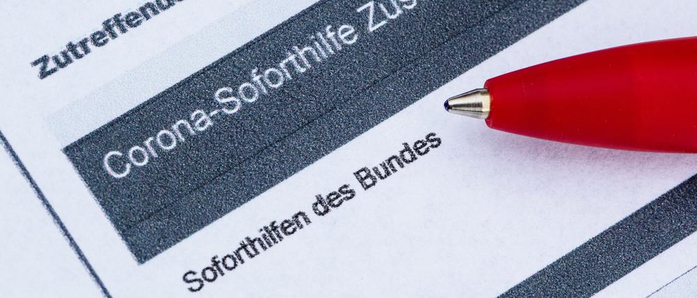Ein Stift liegt auf einem Antrag für den Corona-Soforthilfe-Zuschuss.