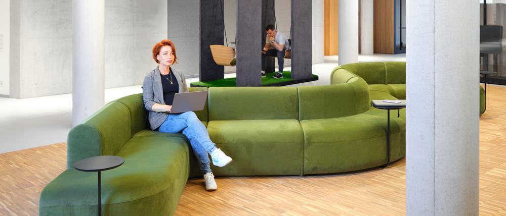 Ein Kommunikationsbereich mit samtgrünen Sofas im neuen Coworking-Space St3am der landeseigenen Wista. 