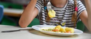 Schüler sitzen beim Mittagessen in der Mensa einer Grundschule.