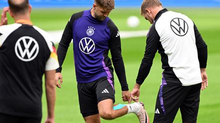 Niclas Füllkrug (M) nach seinem vergeblichen Härtetest beim Abschlusstraining im Gespräch mit Bundestrainer Julian Nagelsmann (r). 