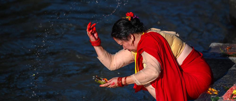 Hier scheint Beten noch zu helfen. Eine gläubige Hinduistin an den Ufern des nepalesischen Bagmati in Kathmandu.