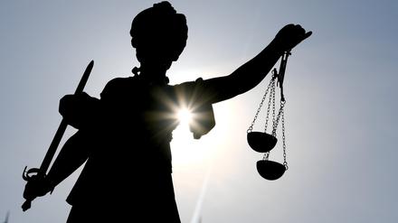 Figur der Göttin Justitia im Gegenlicht.