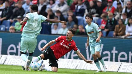 Voller Einsatz: Hannovers Jannik Rochelt (M) im Zweikampf mit Kaiserslauterns Almamy Toure (l)