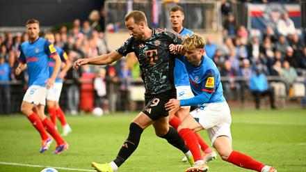 Bayerns Harry Kane (l-r) behauptet den Ball gegen Kiels Finn Porath.
