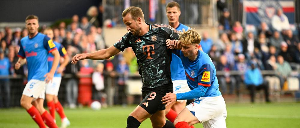 Bayerns Harry Kane (l-r) behauptet den Ball gegen Kiels Finn Porath.
