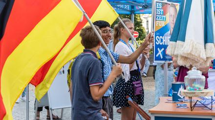 Mitglieder der Jungen Alternative, der Nachwuchorganisation der AfD, schwenken auf einer Wahlkampfveranstaltung der AfD Brandenburg in Cottbus Deutschlandfahnen. +++ dpa-Bildfunk +++