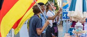 Mitglieder der Jungen Alternative, der Nachwuchorganisation der AfD, schwenken auf einer Wahlkampfveranstaltung der AfD Brandenburg in Cottbus Deutschlandfahnen. +++ dpa-Bildfunk +++