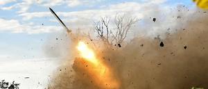 Artilleristen feuern einen RM-70 Mehrfachraketenwerfer nahe der Front ab.