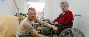 Ein Pfleger bei einer Bewohnerin eines Seniorenwohnheims: Viele Heime finden nicht genug Personal. 
