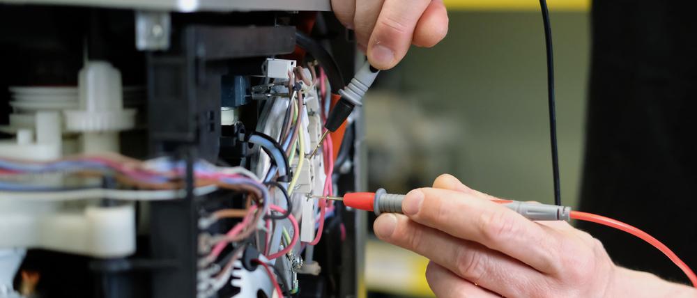 An einem Kaffee-Vollautomaten in einer Reparaturwerkstatt werden elektronische Messgrößen ermittelt.