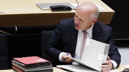 Kai Wegner (CDU), Regierender Bürgermeister von Berlin, blättert in Akten während einer Plenarsitzung im Parlament im Berliner Abgeordnetenhaus. 