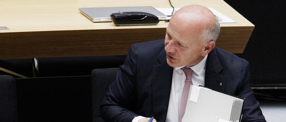 Kai Wegner (CDU), Regierender Bürgermeister von Berlin, blättert in Akten während einer Plenarsitzung im Parlament im Berliner Abgeordnetenhaus. 