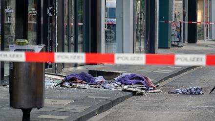 Scherben und Kleidungsstücke liegen vor einem Geschäft in der Ehrenstraße in Köln.