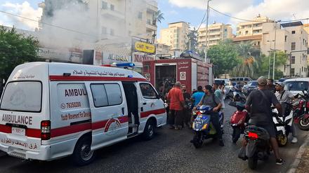 Menschen versammeln sich, als Rauch aus einem Geschäft in Sidon, Libanon, aufsteigt.