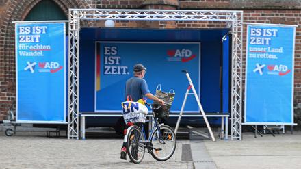 Ein Mann fährt mit seinem Fahrrad vor einer Kundgebung der rechtsextremen Partei AfD (Alternative für Deutschland) für die Landtagswahl in Brandenburg am 19. September 2024 in Cottbus, Ostdeutschland, an der Bühne vorbei. Die Landtagswahl in Brandenburg findet am 22. September 2024 statt.