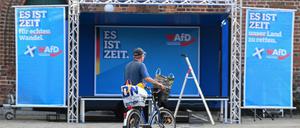 Ein Mann fährt mit seinem Fahrrad vor einer Kundgebung der rechtsextremen Partei AfD (Alternative für Deutschland) für die Landtagswahl in Brandenburg am 19. September 2024 in Cottbus, Ostdeutschland, an der Bühne vorbei. Die Landtagswahl in Brandenburg findet am 22. September 2024 statt.