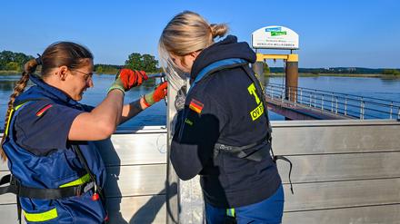 Zwei ehrenamtliche Helferinnen vom Technischen Hilfswerk (THW) errichten eine mobile Hochwasserschutzwand am deutsch-polnischen Grenzflusses Oder.