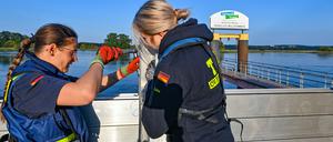 Zwei ehrenamtliche Helferinnen vom Technischen Hilfswerk (THW) errichten eine mobile Hochwasserschutzwand am deutsch-polnischen Grenzflusses Oder.