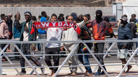 Migranten halten einen Schal des FC Wydad Athletic Club, nachdem sie mit weiteren Menschen von dem spanischen Seenotrettungsdienst an den Hafen gebracht wurden. Insgesamt wurden 117 Migranten nordafrikanischer und subsaharischer Herkunft gerettet und an den Hafen gebracht. 