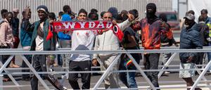 Migranten halten einen Schal des FC Wydad Athletic Club, nachdem sie mit weiteren Menschen von dem spanischen Seenotrettungsdienst an den Hafen gebracht wurden. Insgesamt wurden 117 Migranten nordafrikanischer und subsaharischer Herkunft gerettet und an den Hafen gebracht. 