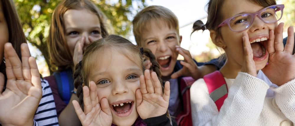 Mehrere Kinder schreien fröhlich und die legen dabei die Hände als Trichter ans Gesicht.