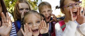Mehrere Kinder schreien fröhlich und die legen dabei die Hände als Trichter ans Gesicht.