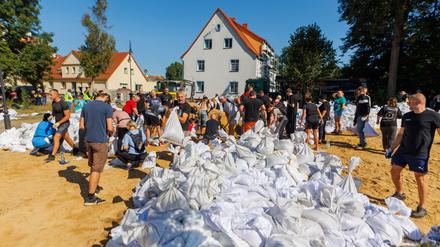 Menschen arbeiten in Polen an der Verstärkung der Deiche.