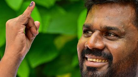 Der Präsidentschaftskandidat der Partei National People’s Power (NPP), Anura Kumara Dissanayaka, zeigt seinen eingefärbten Finger, als er ein Wahllokal verlässt, nachdem er seine Stimme während der Präsidentschaftswahlen in Sri Lanka am 21. September 2024 in Colombo abgegeben hat.