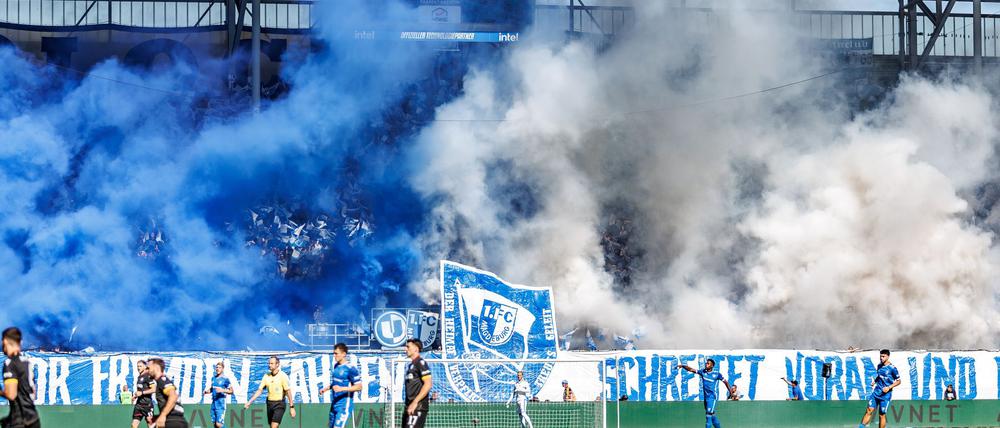 Die Magdeburger Fans zeigen ein fragwürdiges Banner und betonen dies mit Pyrotechnik.