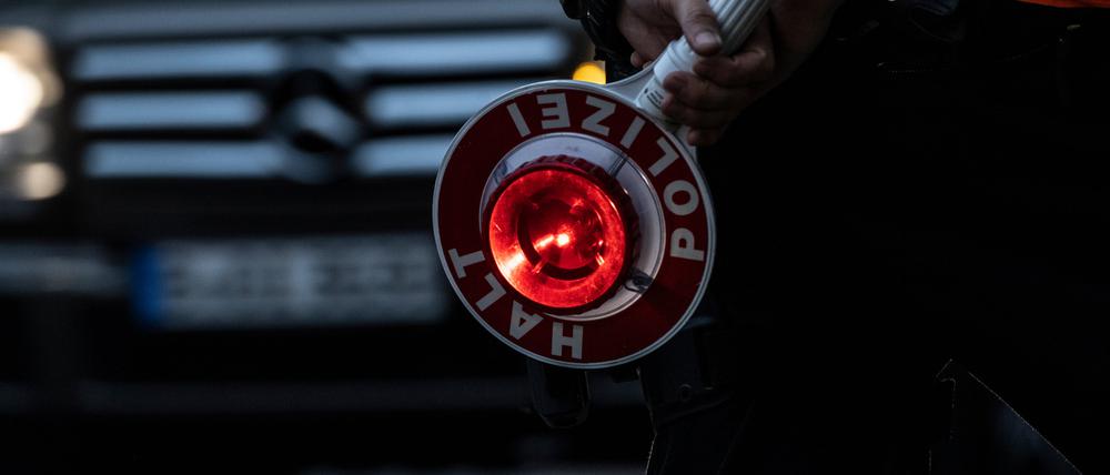 „Halt! Polizei!“ steht auf der Kelle eines Polizeibeamten. (Symbolbild)