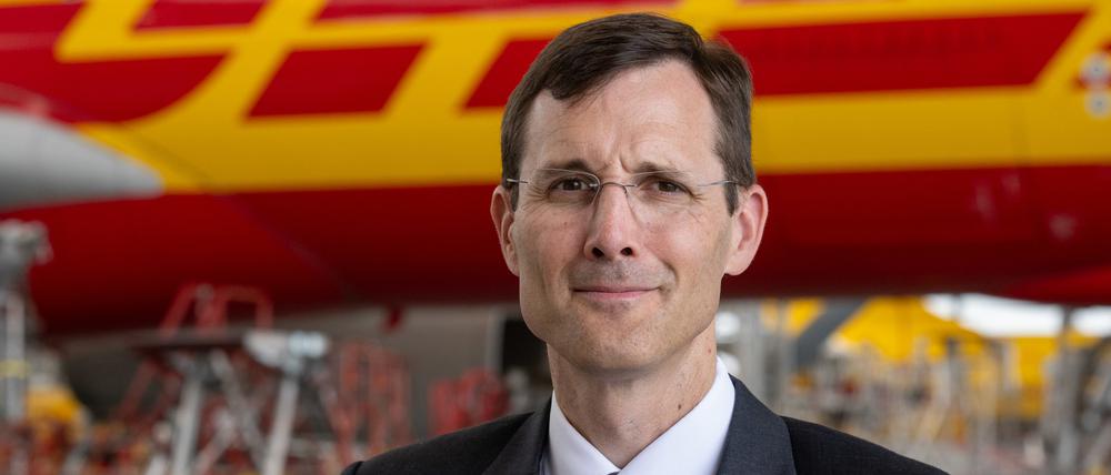 Tobias Meyer, Vorstandsvorsitzender von DHL, steht im Frachtzentrum am Flughafen Leipzig/Halle vor einem Airbus A330. 